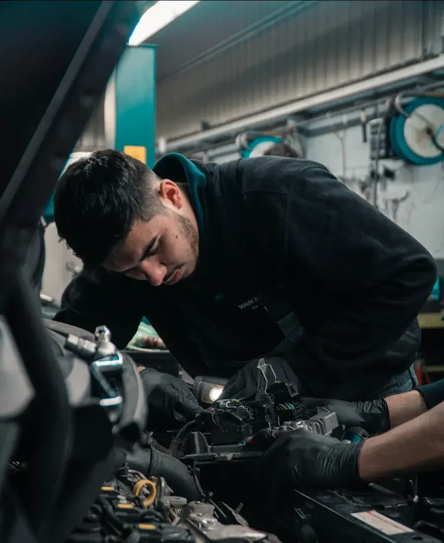 Technik prohlíží motor a stav vozidla